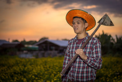 Man holding umbrella while standing on field