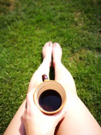Low section of woman holding coffee cup