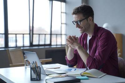 Businesswoman talking on phone while sitting at office