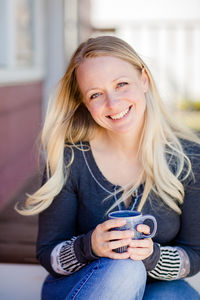 Portrait of smiling young woman using mobile phone