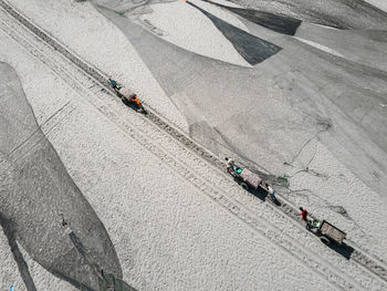 High angle view of people walking on snow covered landscape