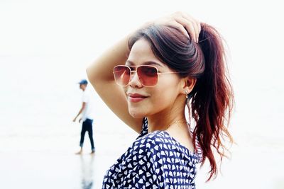 Portrait of young woman standing against sky