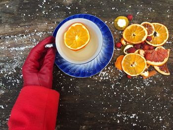 View of gloved hand with orange tea on table