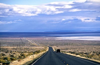 Road by landscape against sky