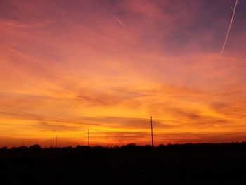 Silhouette landscape against dramatic sky during sunset