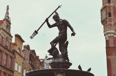 Low angle view of neptune fountain against sky