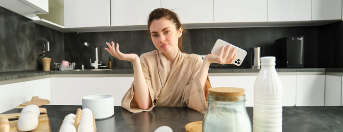 Portrait of young woman drinking coffee at home