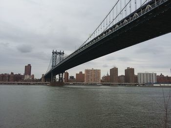 Bridge over river against cloudy sky