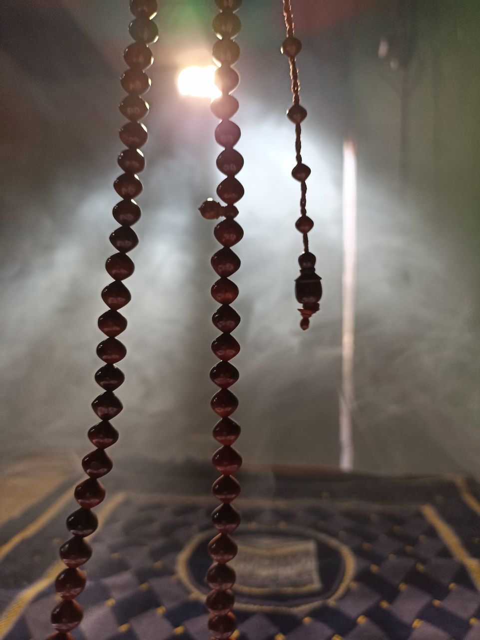 no people, chain, metal, indoors, focus on foreground, light, close-up, necklace, bead
