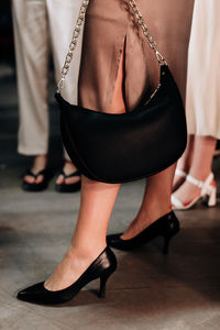 Fashion details of black leather handbag and high heels shoes. classy outfit female look