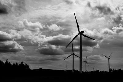 Low angle view of traditional windmill against cloudy sky