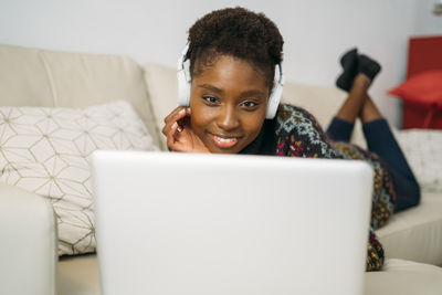 Man using mobile phone while sitting on sofa at home