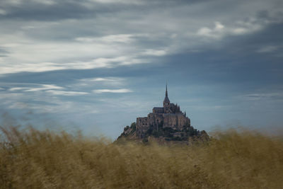 View of temple building against cloudy sky