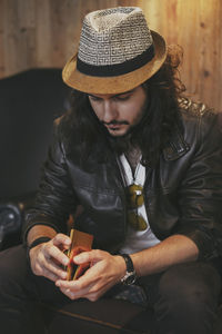 Young man wearing hat sitting on sofa at home