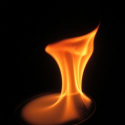 Close-up of lit candle in dark room