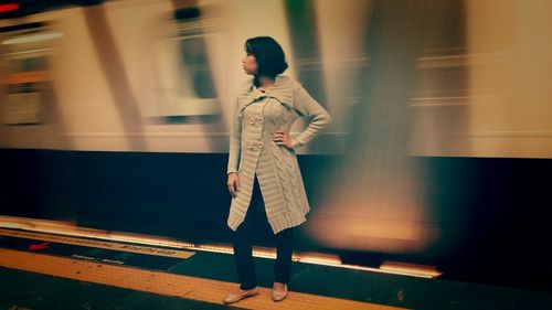 Full length of woman standing by railing