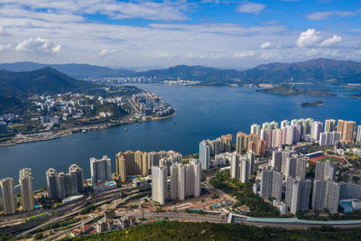 High angle view of city by sea against sky