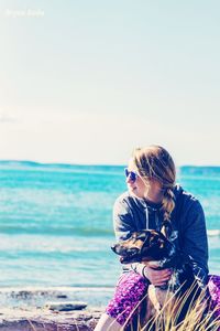 Woman standing at beach against sky