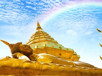 Low angle view of statue against temple building against sky