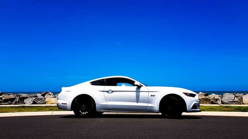 Car on road against clear blue sky