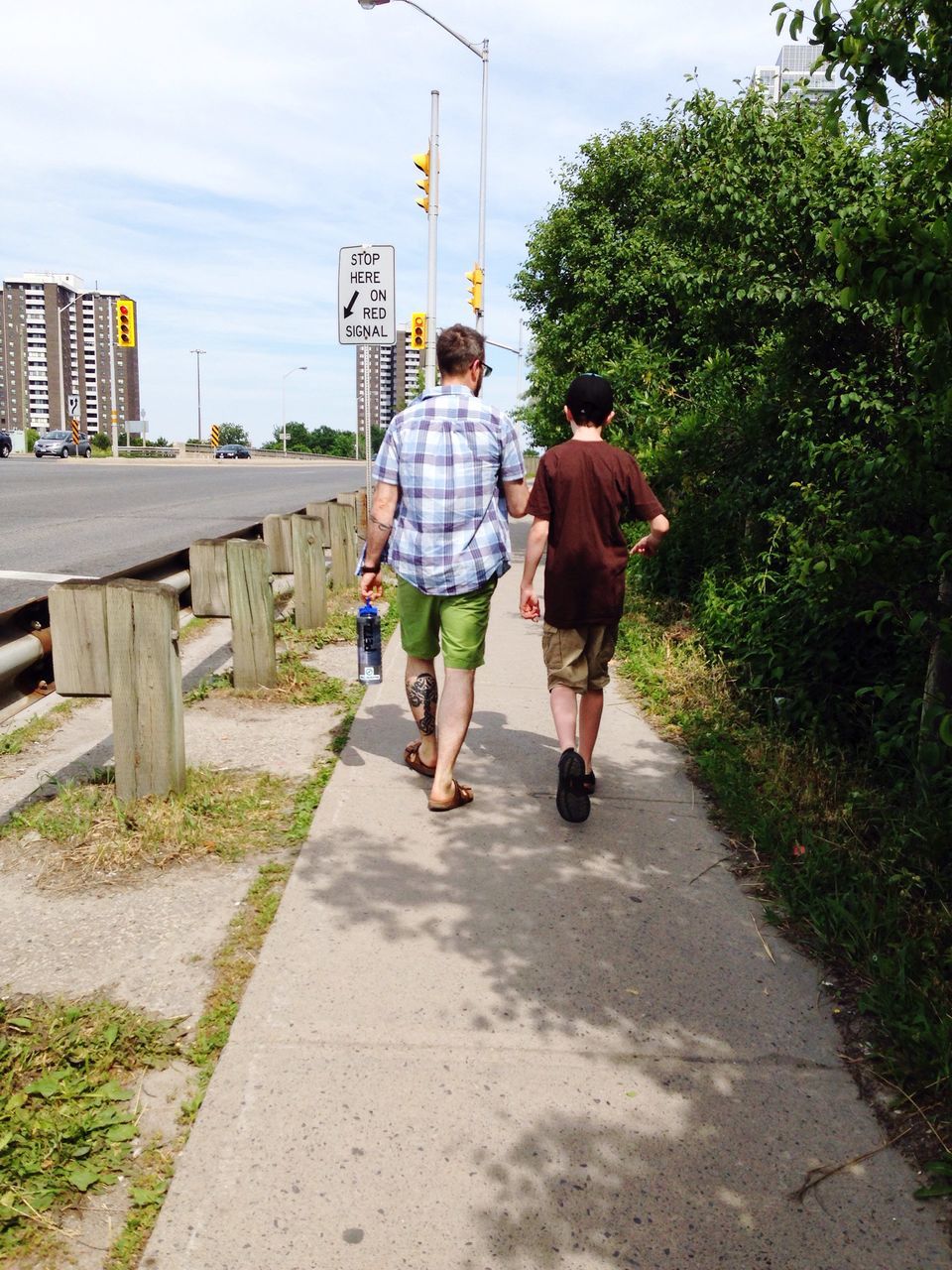 full length, lifestyles, tree, the way forward, leisure activity, casual clothing, sky, day, footpath, outdoors, city, vanishing point, growth, diminishing perspective, city life, plant