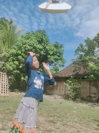 Woman standing by plants against sky