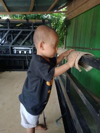 High angle view of boy standing on wooden wall