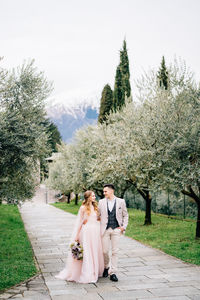 Friends standing on field by trees