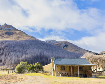 Scenic view of house and mountains against sky