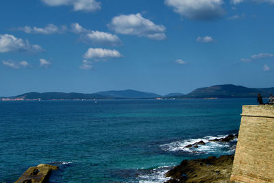 View of calm blue sea against cloudy sky