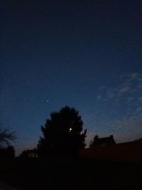 Silhouette of trees against sky at night