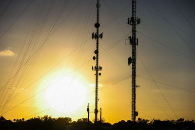 Silhouette electricity pylon against sky during sunset