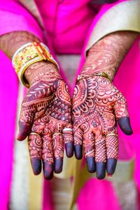 Midsection of bride showing henna tattoo