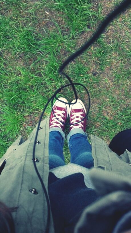 low section, person, shoe, lifestyles, personal perspective, leisure activity, men, footwear, high angle view, grass, jeans, standing, human foot, unrecognizable person, day, outdoors, green color