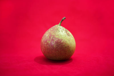 Close-up of apple against red background