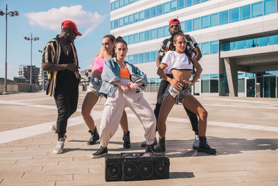 Friends dancing against building in city