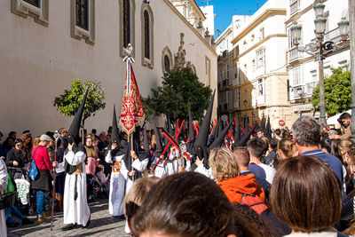 People on street against buildings in city