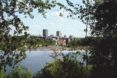 Scenic view of lake by buildings against sky