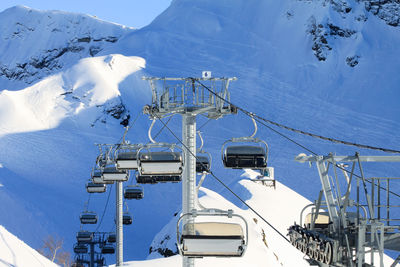 An empty chairlift cabin. in the background snowy slopes with traces of fans of off-piste skiing.