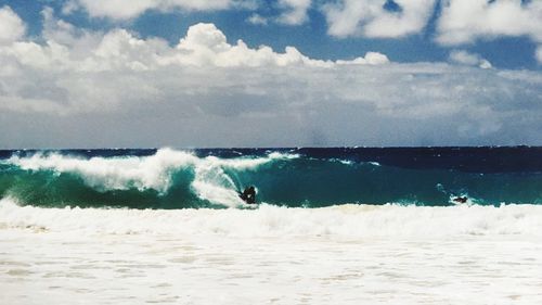 Man surfing on sea against sky