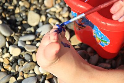 Close-up of hand holding red pebbles