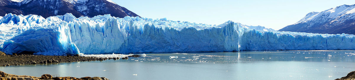 Panoramic view of frozen lake against sky