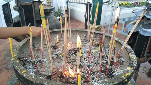 Close-up of burning candles in temple against building