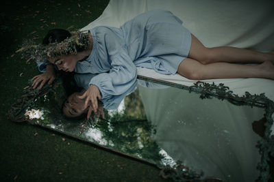 Rear view of girl lying down on bed