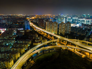 High angle view of illuminated city against sky at night