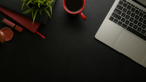 Directly above shot of coffee cup with digital tablet on table