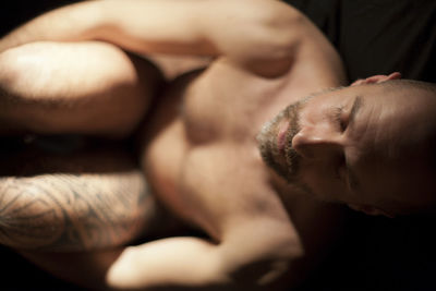 Close-up of shirtless man with eyes closed