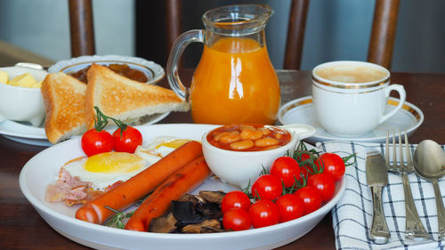 Traditional full english breakfast fried eggs, sausages, beans, tomatoes, toasts. high resolution
