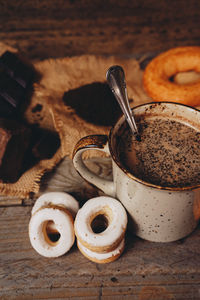 Hot chocolate by doughnuts on table