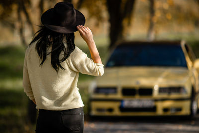 Rear view of woman wearing hat standing outdoors bmw e36 